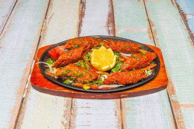 Aşçılık kontrastı tabağı: ince ton balıklı tataki dilimleri, dıştan kurutulmuş ve içeriden yakut kırmızısı, soya ve zencefil sosu ile kaplanmış.