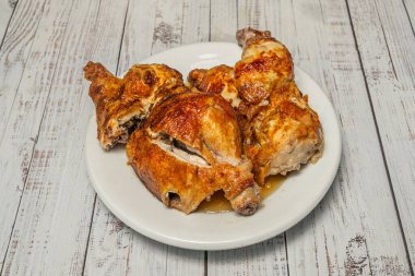 Geleneksel olarak kızarmış tavuğun yarısı kendi karamelli sularıyla kavrulmuş soğan yatağında servis edilir ve koçanda mısır ve jöleli havuçla servis edilir.