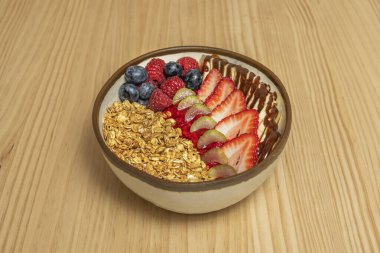 Sabah ışığı balın tatlı çiğ tanelerini aydınlatır. Meyve, yulaf ve fındıkların zengin bir karışımına düşer.