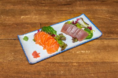 Japon saşimi, somon, mavi yüzgeçli ton balığı ve taze levrek dilimleri ezilmiş buz üzerinde daikon turpuyla sunuldu.