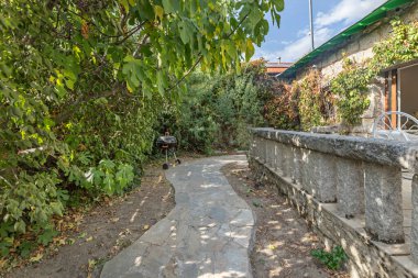 Granit levhalarla ve Santolina sınırlarıyla bir çevre yolu. Bitkilerin gümüşi tonlarının taşın doğal rengine karşı durduğu bir yer.