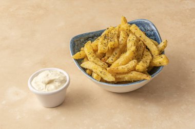 Klasik bir altın, çıtır çıtır patates kızartması tabakta sunuluyor. Yanında da küçük kaselerde birkaç ev yapımı sos var.