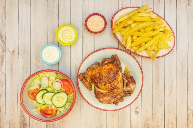 Kızarmış tavuklu sandviç, ev yapımı patates kızartması ve lahana salatası, ballı hardal ve barbekü sosuyla servis edilmiş.