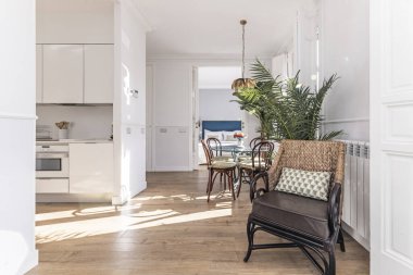 Mobilyaları temiz, düşük profilli bir kanepesi ve yüzen sertleştirilmiş cam rafı olan oturma odası.