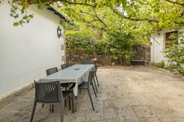 Terasta sentetik reçine yemek masası kireç taşı cepheli ve palmiyelerin arasından süzülen gölgeli..