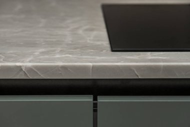 Mermer tezgahlı ve yeşil ahşap kapılı bir mutfağın ayrıntıları.