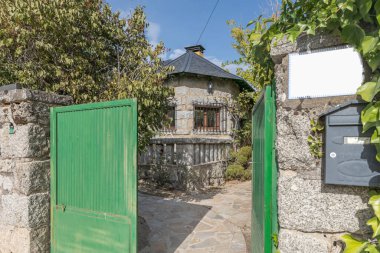 Evin yan görünüşü cam perde duvarını gösteriyor. Geleneksel yük taşıyan duvarlardaki gri granitin kaba dokusuyla çelişiyor.