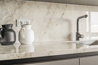 Kablosuz su bidonları mutfak lavabosunun yanında mermer tezgahlı.