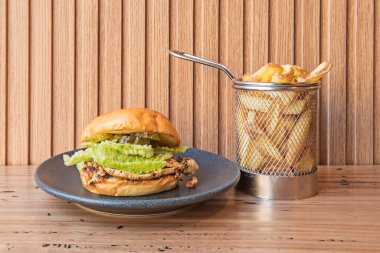 Tatmin edici bir yemek: sulu etiyle hamburger, parlayan çedar peyniri ve kızarmış patatesler her lokmada birbirlerini tamamlıyorlar.