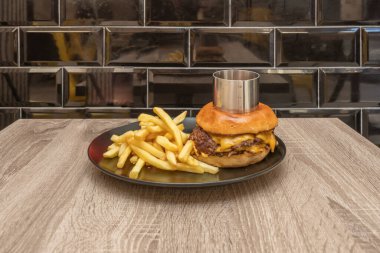 Hamburgerin yüzeyini erimiş, parlayan ve aromatik bir çedar seli kaplıyor ve sizi ilk ısırığı almaya davet eden her hareketle altın iplikler oluşturuyor..