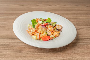 Büyük dilimlenmiş tavuk göğsü, Sichuan biberi, kurutulmuş acı biber ve kaliteli soya soslu gurme usulü karides, hassas bir dokunuşla sunulur.