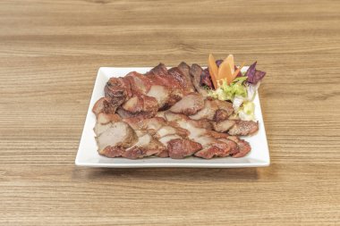  Kızarmış domuz eti, kurutulmuş biber ve fıstık, seramik bir kasede pirinç ve dilimlenmiş yeşil soğanla sunulur.