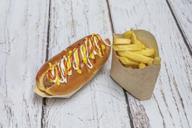 Basit bir sanat eseri: sulu, hafif dumanlı bir sosis pürüzsüz bir tavada duruyor, sarı hardal ve çıtır çıtır bir sosisin tepesinde parlak bir ketçap fışkırıyor.