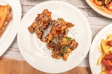 Yavaş pişirilmiş domuz pirzolası barbekü sosuna karıştırılmış ve kremalı lahana salatalı çöreğin içinde servis edilmiş.