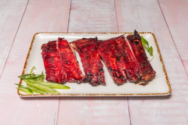 Koyu soya soslu kızarmış domuz eti ve yanında da kızarmış bok choy ve taze salatalık dilimleri.