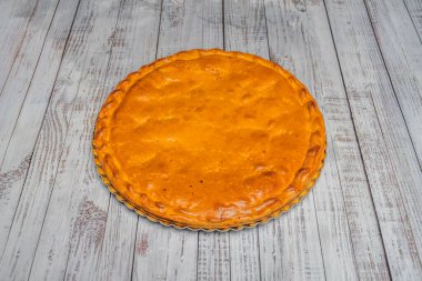 Geleneksel Galiçya et böreği, kenarlarında altın puf hamur kabuğu olan, bir çam ağacından bir tahtanın üzerinde bütün olarak sunuluyor.