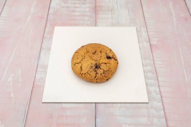 Büyük ve küçük çikolata parçalı klasik çikolatalı kurabiye kenarları hafif çıtır çıtır ama ortası yumuşak olan altın bir pastaya eşit olarak dağıtılıyor.