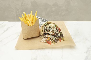 Baharatlı basmati pilavı, domates ve salatalık salatası ve sarımsak sosuyla servis edilen tavuk shawarma.