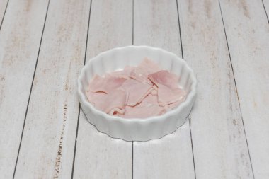 Beyaz bir masanın üzerinde küçük, yuvarlak, beyaz bir porselen tabağı.