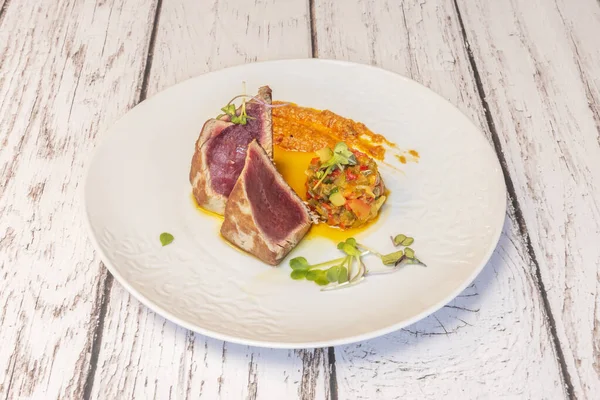 Ton balığının mükemmel dokusunu gösteren detaylı bir yakın plan: susam ve biberin dış kabuğu taze, tereyağlı içiyle çelişiyor.