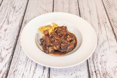 Cordoban tarzında hazırlanmış buharlı bir sığır kuyruğu güveci, biraz brendi ve aromatik otlarla servis edilmeye hazır.