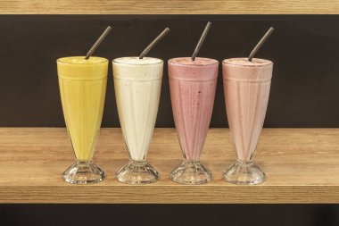 Meşe ağacından bir rafta çeşitli tatlardan oluşan bir sıra meyve püresi