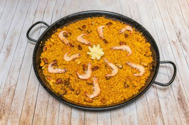 İkiye bölünmüş ıstakozlu deniz ürünleri paella, büyük karidesler ve midyeler, özel durumlar için lüks bir ana yemek.