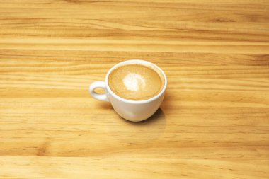 Beyaz bir porselen fincanda köpükle servis edilen bir cortado kahvesi.