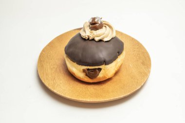 Yumuşak brioche hamurlu çikolatalı bir Berliner, sütlü çikolata ganache ile dolu ve parlak çikolatalı fondant jöleli.