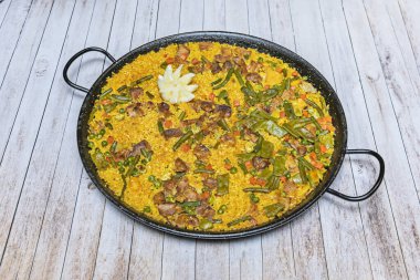 Gevşek, birbirinden ayrılmış, safran ve paprikayla tatlandırılmış Bomba pirinç tanelerinin yakın plan çekimi..