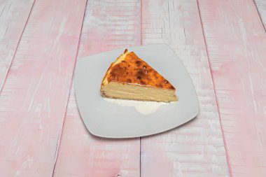Ev yapımı yabanmersini kompostosu ile kaplı Philadelphia usulü cheesecake dilimi, karamel sosu üzerine servis edilir ve çikolata yağmuruyla süslenir.