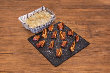 Geleneksel domuz katliamından kalma domuz eti, kabaca kesilmiş ve bol bol yağsız et ile, içi yumuşayana kadar yavaşça kızartılmış, dışı ise altın sarısı kahverengi.