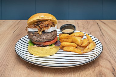 Kalın kesimli, ızgara Angus bifteği, erimiş çedar peyniri damlatan bir gurme burger ve bol miktarda ev yapımı, altın ve tuzlu patates kızartmasıyla servis edilen gevrek domuz pastırması.