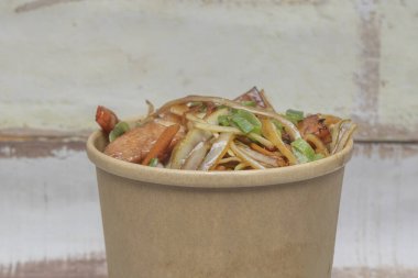 Tipik bir karton paket servis konteynırı, kızarmış Çin eriştesinin bol miktarda tavuklu, fasulyeli ve taze soğanlı kısmını gözler önüne sermek için açıldı.