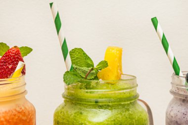 Yeşil elma, salatalık, zencefil ve ıspanaktan yapılmış uzun bir sürahide canlandırıcı limon yeşili bir içecek, dipte hafif bir doğal meyve suları ayrımı gösteriyor.