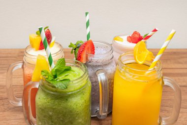 Cam kavanozlarda, saplı bir içecek koleksiyonu, her biri düzgün ve tek parça halinde, muz-vanilya, çikolata-fındık ve karışık böğürtlen-yoğurt gibi tatları temsil eden parçalar içeriyor..