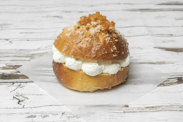 Krem rengi halka şeklinde bir kekin çapraz kesitli görüntüsü. Kırıntıların içindeki hava kabarcıkları görülebilir. Saf beyaz dolgunun pürüzsüz ve kompakt dokusuyla çelişiyor.