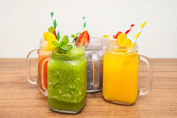 Geniş ağızlı kavanozlardan oluşan bir düzenleme. Smoothie 'ler ince bir renk gradyanı sergiliyor. İlk başta kireç yeşilinden son olarak canlı bir portakala kadar.