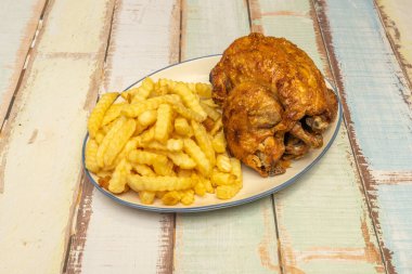 Bir tabağa kaydedilmiş bir Pazar ritüeli: Patates ve havuçlarla çevrili kızarmış bir tavuğun geleneksel görüntüsü, ev ve aile toplantılarının sıcaklığını sembolize ederek, kendi yağında kahverengileşmiştir.