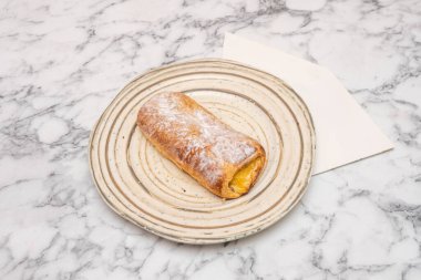 Napolitanın mükemmel bir şekilde mühürlenmiş ve kaplanmış dış yüzeyi, tuhaf kalbinde saklı olan zengin çift dolgu hakkında hiçbir ipucu vermez..