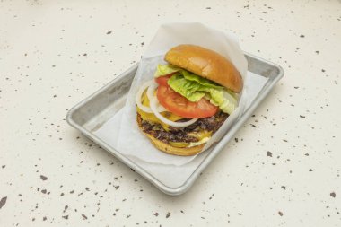 Klasik ve yenilikçi arasındaki uyum: erimiş peynir merkezli iki biftek köftesi, çıtır pastırma, tatlı ve ekşi turşu.