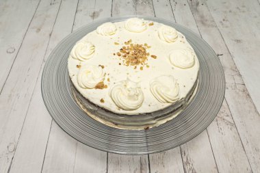 Pastanın jöleli hali, krem peynirin pürüzsüzleşmesini bir spatulayla yakalıyor, şekerli havuç parçacıklarıyla süslenmeye hazır..