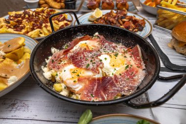 Pişmiş jambonlu kırık yumurtalar, daha hafif bir versiyon, küçük parçalara bölünmüş ve patates ve kızarmış yumurtalarla karıştırılmış.