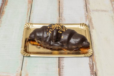 Yeni pişmiş kruvasan ikiye bölündü. Erimiş tereyağı yumuşak havada parlarken havada hapsolmuş aromatik buharı var.