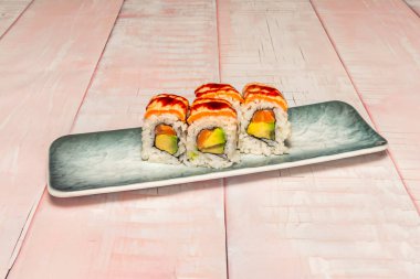 Dikdörtgen bir tabakta uramaki rulolarının çeşitliliği, her rulo kendi görünür dış bileşenleri nedeniyle farklı bir görünüm içerir