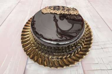 Kırmızı kadife ya da koyu çikolatalı kekin üzerine ustalıkla damlayan beyaz kremalı süslemeyle oynayan bir resim.,