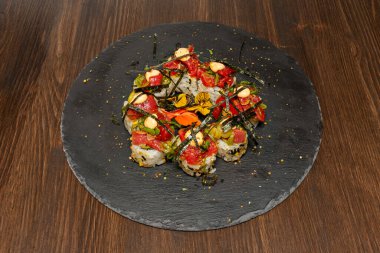 Tepside sunulan çeşitli uramaki ruloları her bir parçanın mükemmel kesimini ve içindeki rengarenk dolguları vurguluyor.