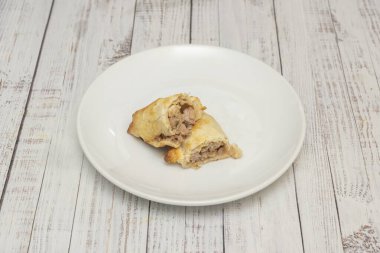 Gelenek ve yenilik arasındaki mükemmel denge: klasik sığır eti böreğinin modern kuru üzümlü ton balığı versiyonlarıyla yan yana gelmesi veya Rokfor peyniri ve cevizi ile evrimini gösteren kompozisyon