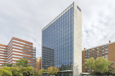 Dış yüzeyini kesintisiz olarak kaplayan dikdörtgen pencerelerden oluşan bir kamusal bina..