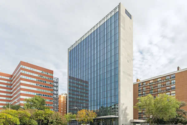 Dış yüzeyini kesintisiz olarak kaplayan dikdörtgen pencerelerden oluşan bir kamusal bina..